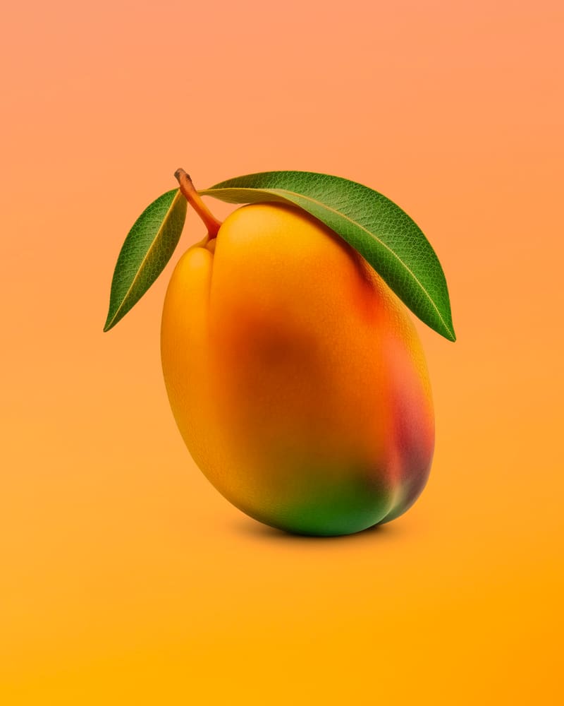 Een rijpe mango met blaadjes voor een oranje achtergrond